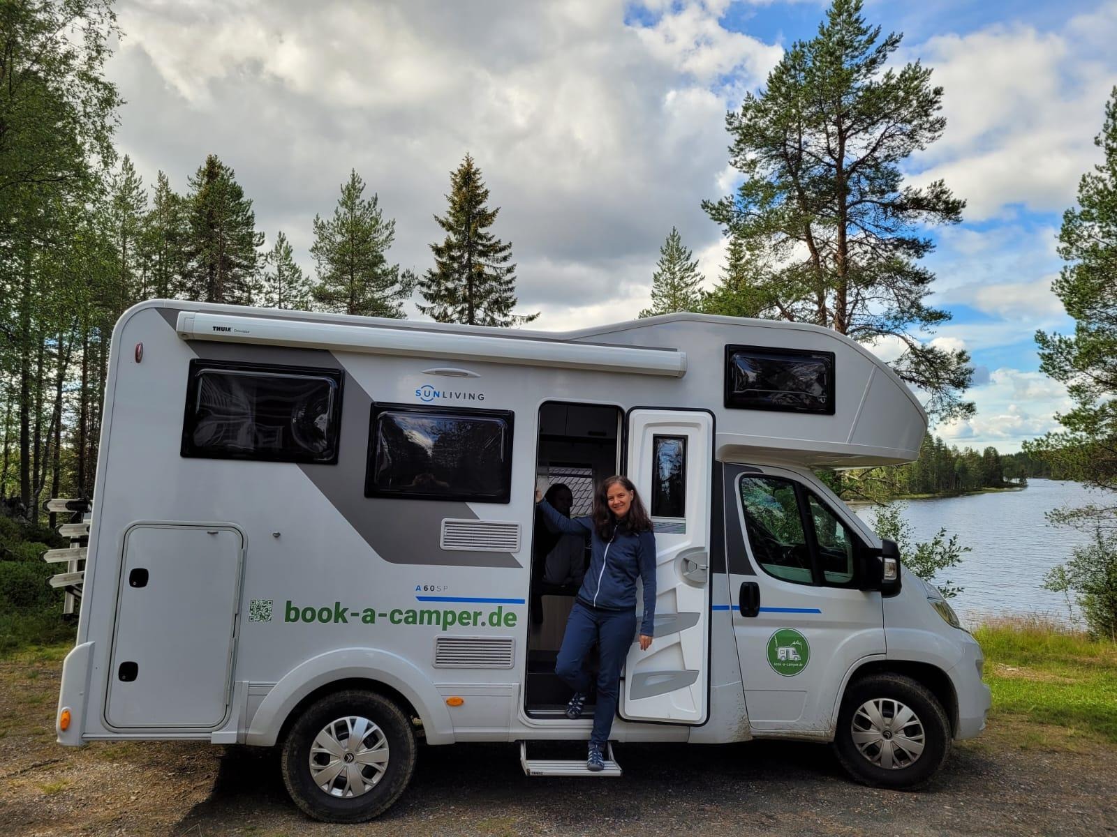 Idyllischer Blick auf die Einstiegsseite eines 5,99m Campers mit Alkoven auf einer Landstraße in Finnland